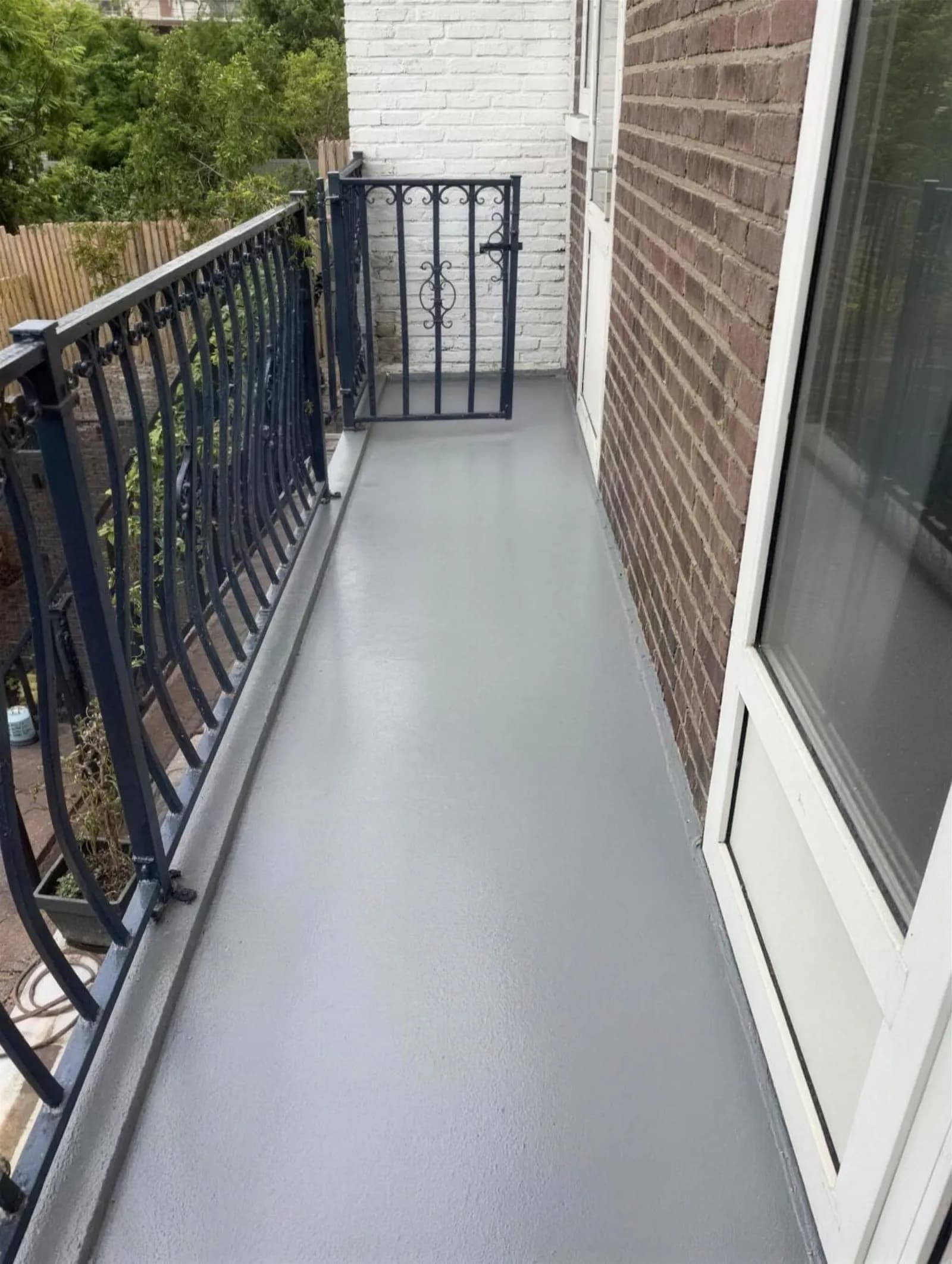 Balkon met smeedijzeren hekwerk en vernieuwde, naadloos gecoate vloer