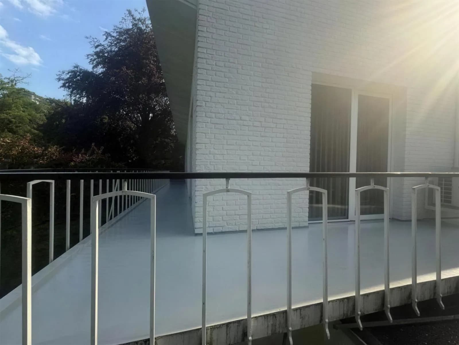 Zonnig wit balkon met strak afgewerkte coatingvloer